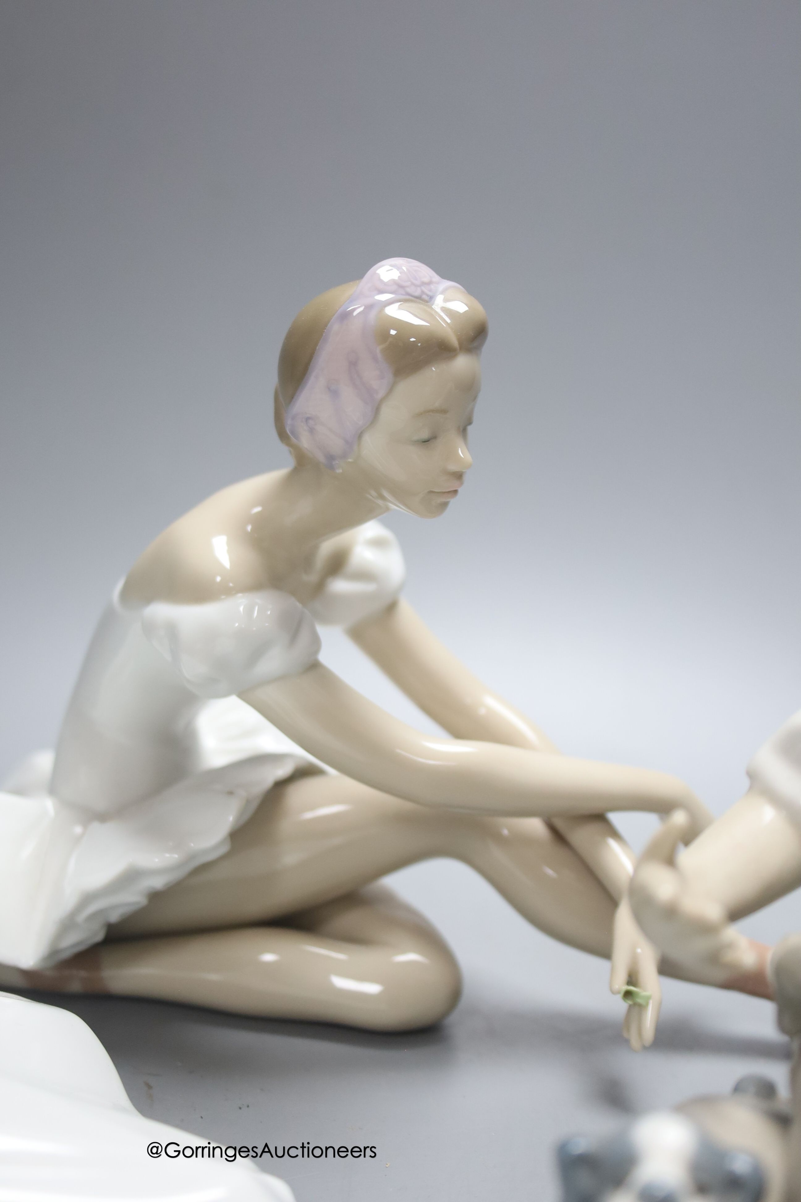 A Lladro figure of a ballerina and a child playing with dogs, height 21cm, and a Nao ballerina